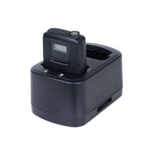 Single wireless bodypack transmitter with LCD display seated in a single-slot charging cradle, shown in black